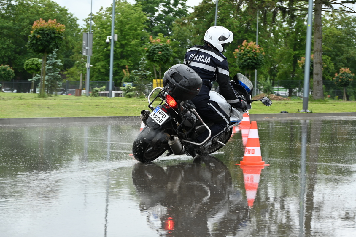 Policjant na motocyklu służbowym pokonuje tor przeszkód