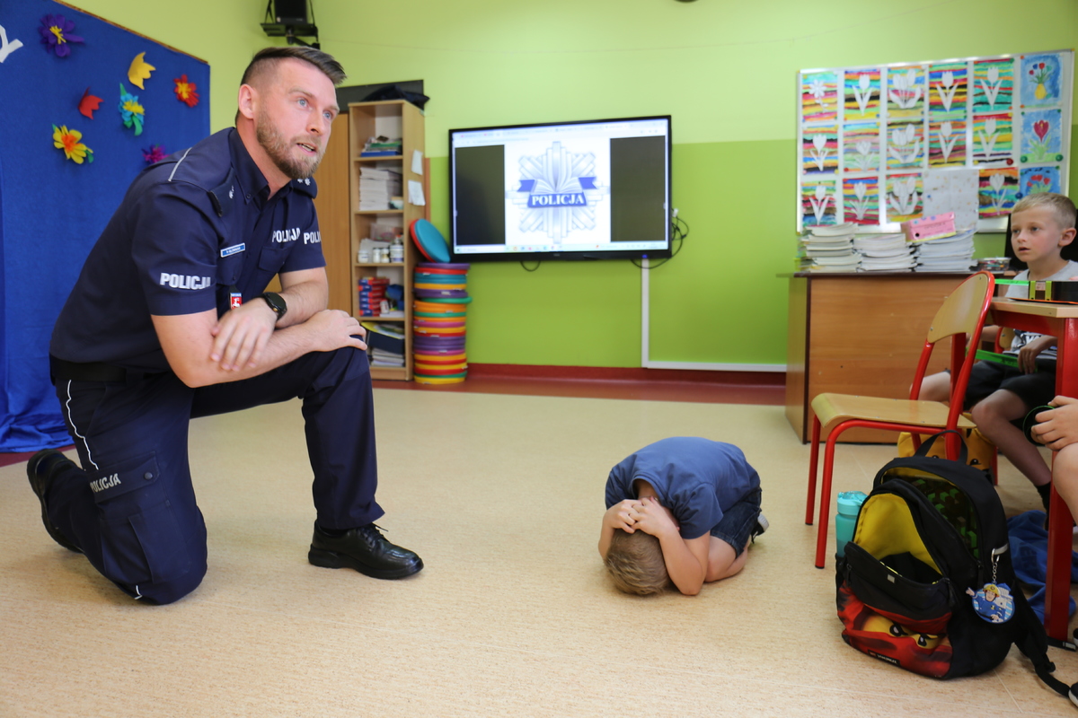 policjant i dziecko pokazujące pozycję zółwia