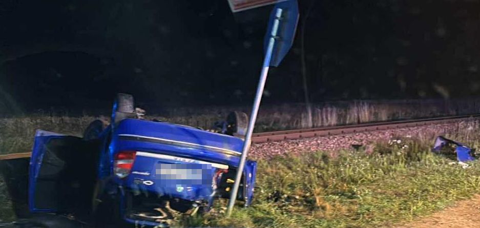 auto leżące na dachu przy torach