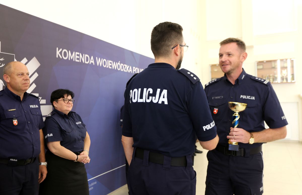 komendant wręcza puchar policjantowi