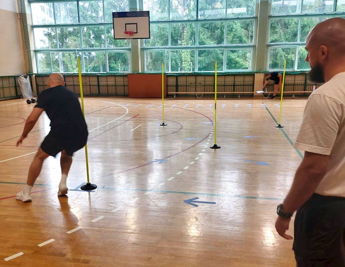 kandydat zdaje test sprawności fizycznej pod okiem policjanta