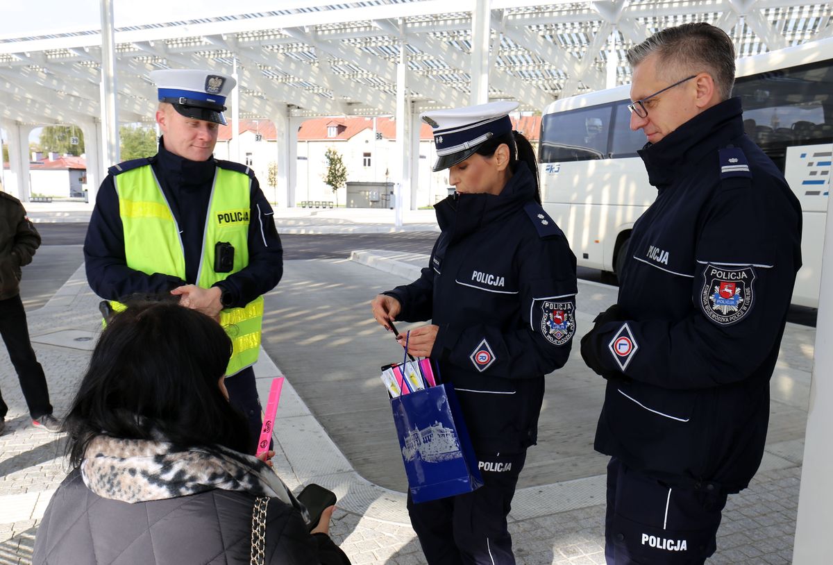 policjanci rozdają odblaski na dworcu