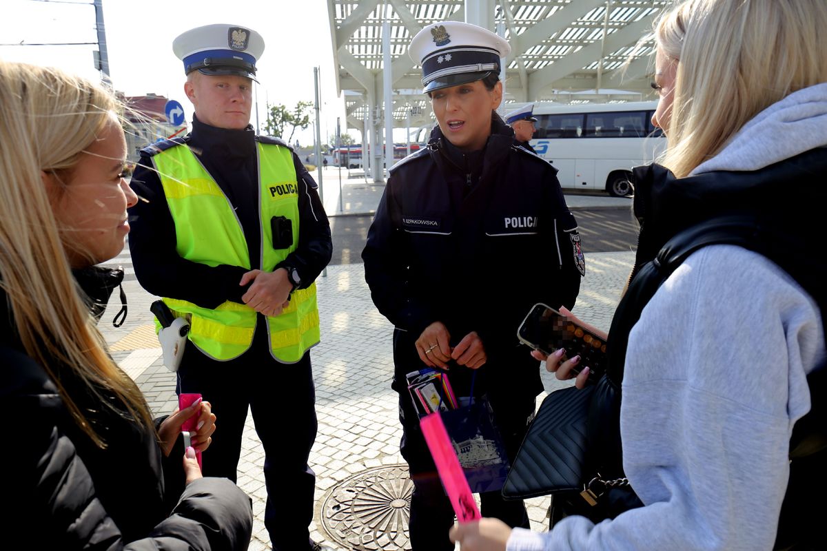 policjanci rozdają odblaski na dworcu