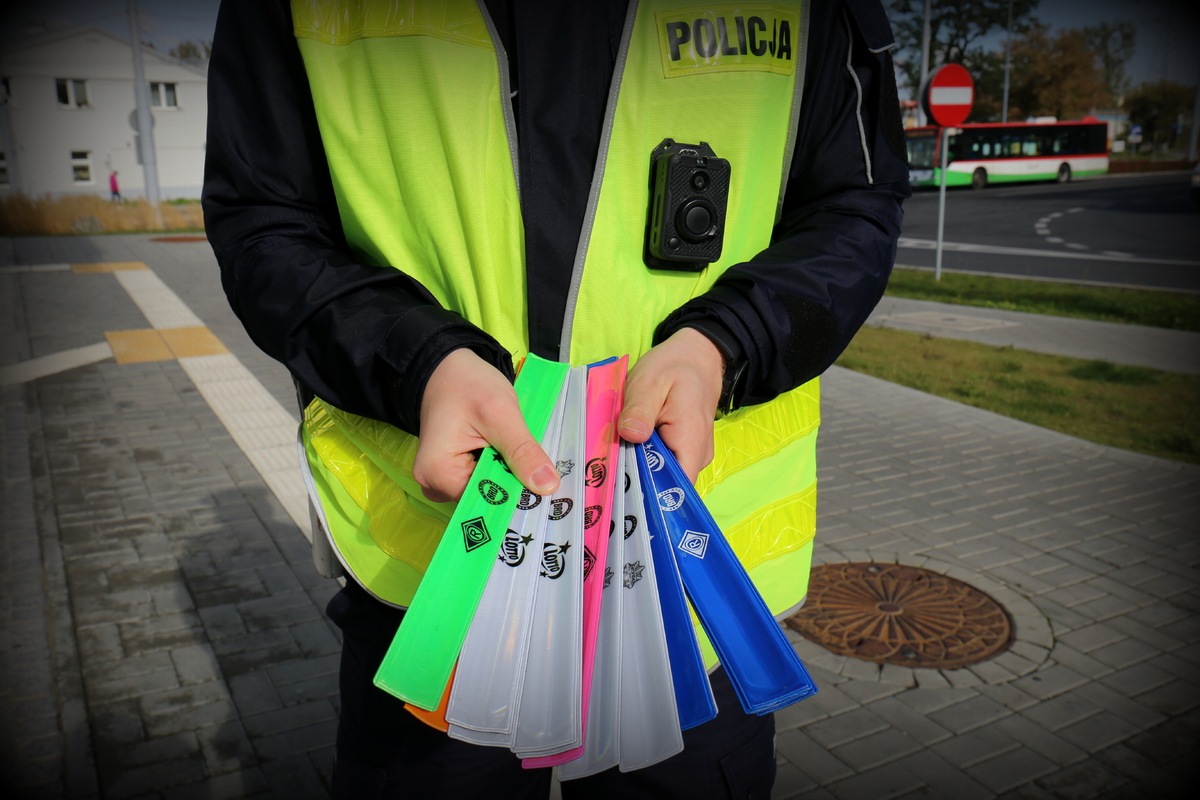 policjant trzyma w ręku odblaski