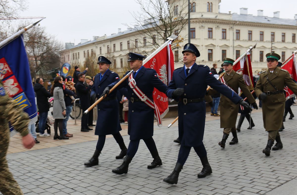 policjanci w poczcie sztandarowym idą w defiladzie