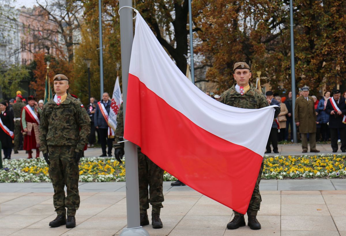 żołnierze wciągają flagę Polski na maszt 