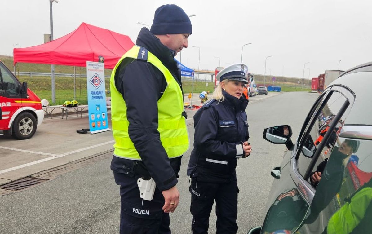policjantka i policjant rozmawiają z kierowcą samochodu osobowego