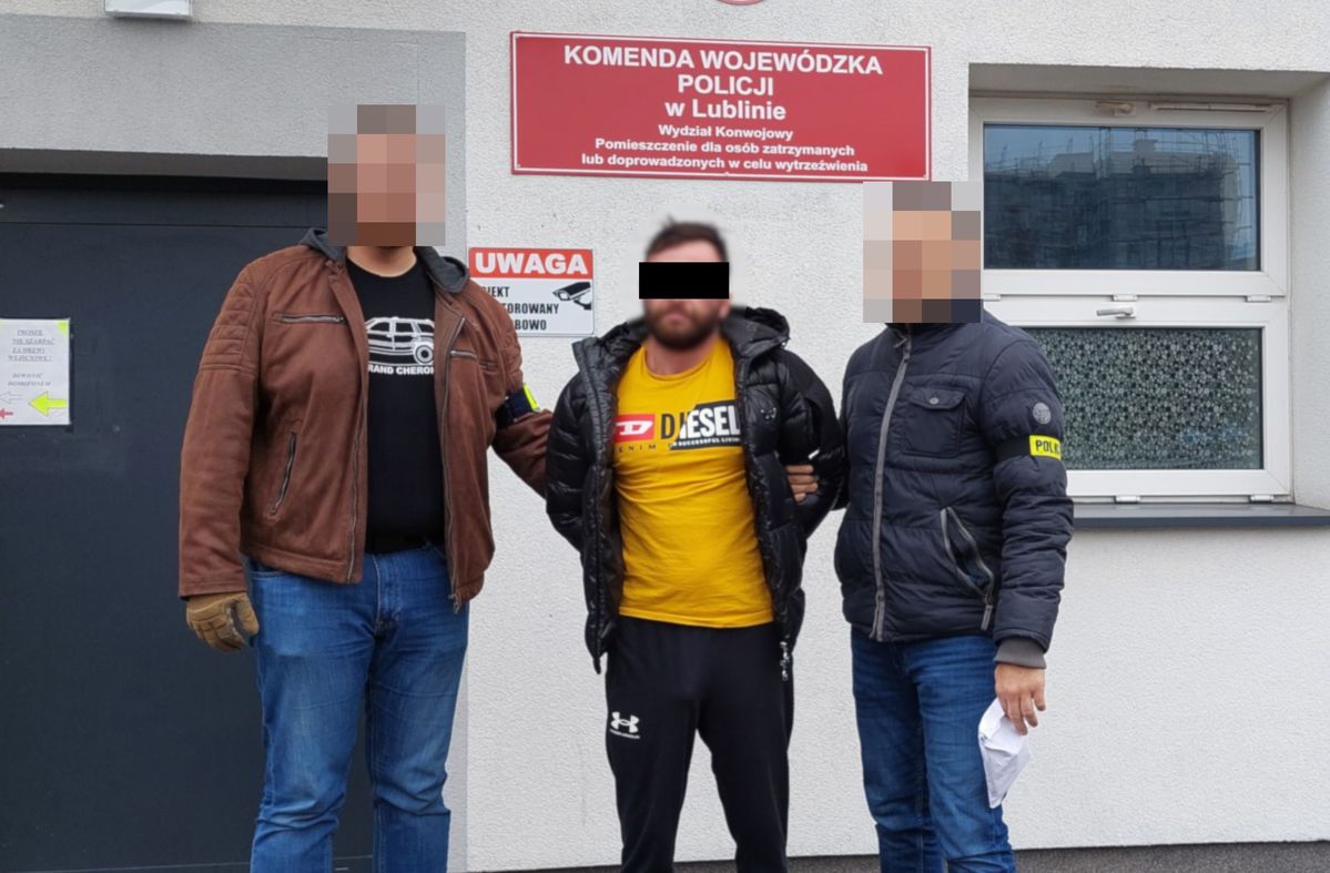 Policjanci prowadzą zatrzymanego mężczyznę.