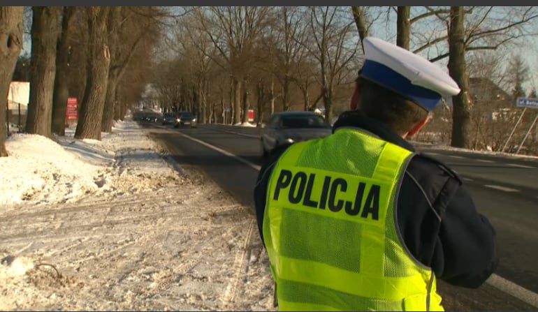 policjant przy drodze z miernikiem prędkości