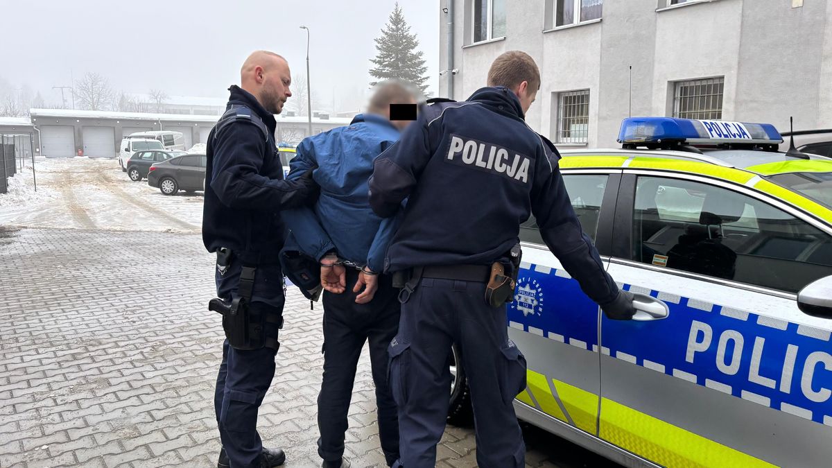 Policjanci prowadzą zatrzymanego mężczyznę.