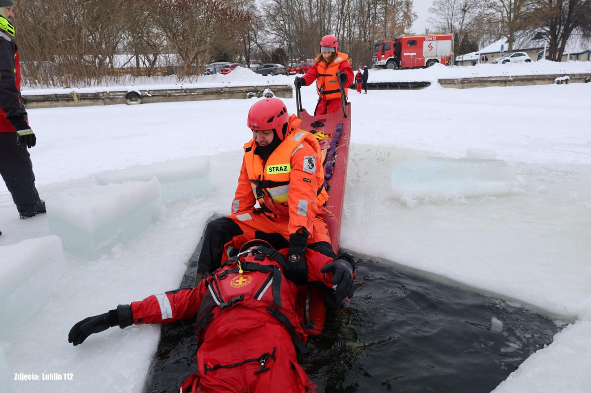 Policjanci ćwiczą udzielanie pomocy osobie pod którą zapadł się lód na zbiorniku wodnym.