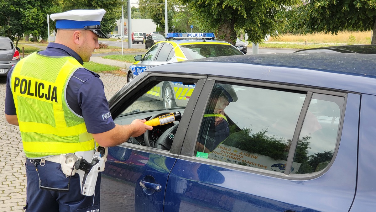 Policjant kontroluje trzeźwość kierowcy.