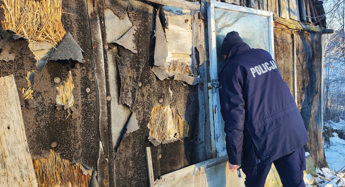 Policjant sprawdza czy w opuszczonym domu ktoś jest