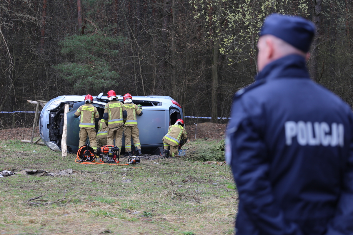 Strażacy udzielają pomocy osobom uwięzionym w rozbitym aucie.