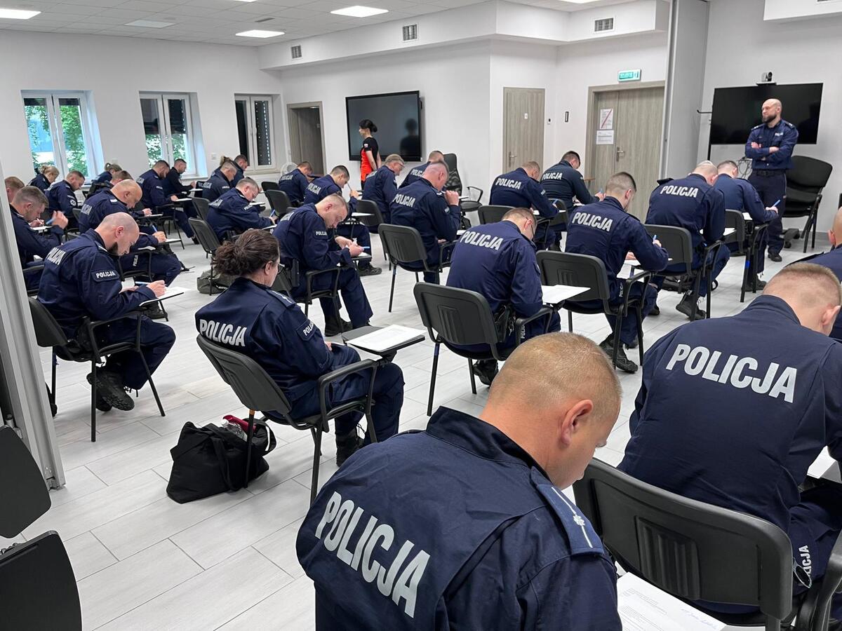 umundurowani policjanci siedzą w ławkach i rozwiązują test