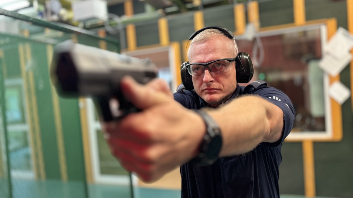 Policjant na strzelnicy strzela do traczy.