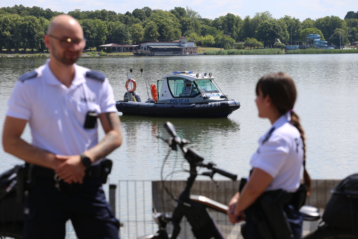 W pierwszym planie policjanci z patrolu rowerowego w drugim planie policjanci na łodzi.