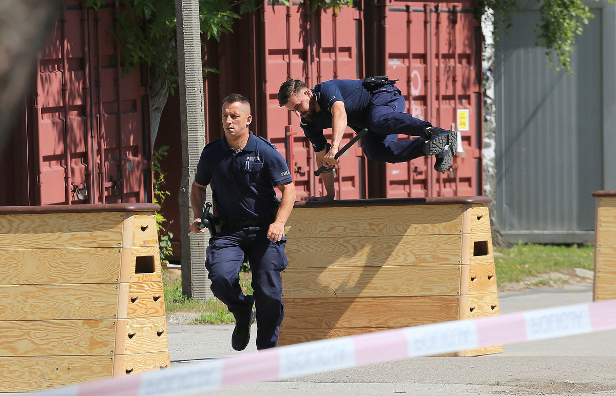 Policjanci przeskakują przez szkynię.