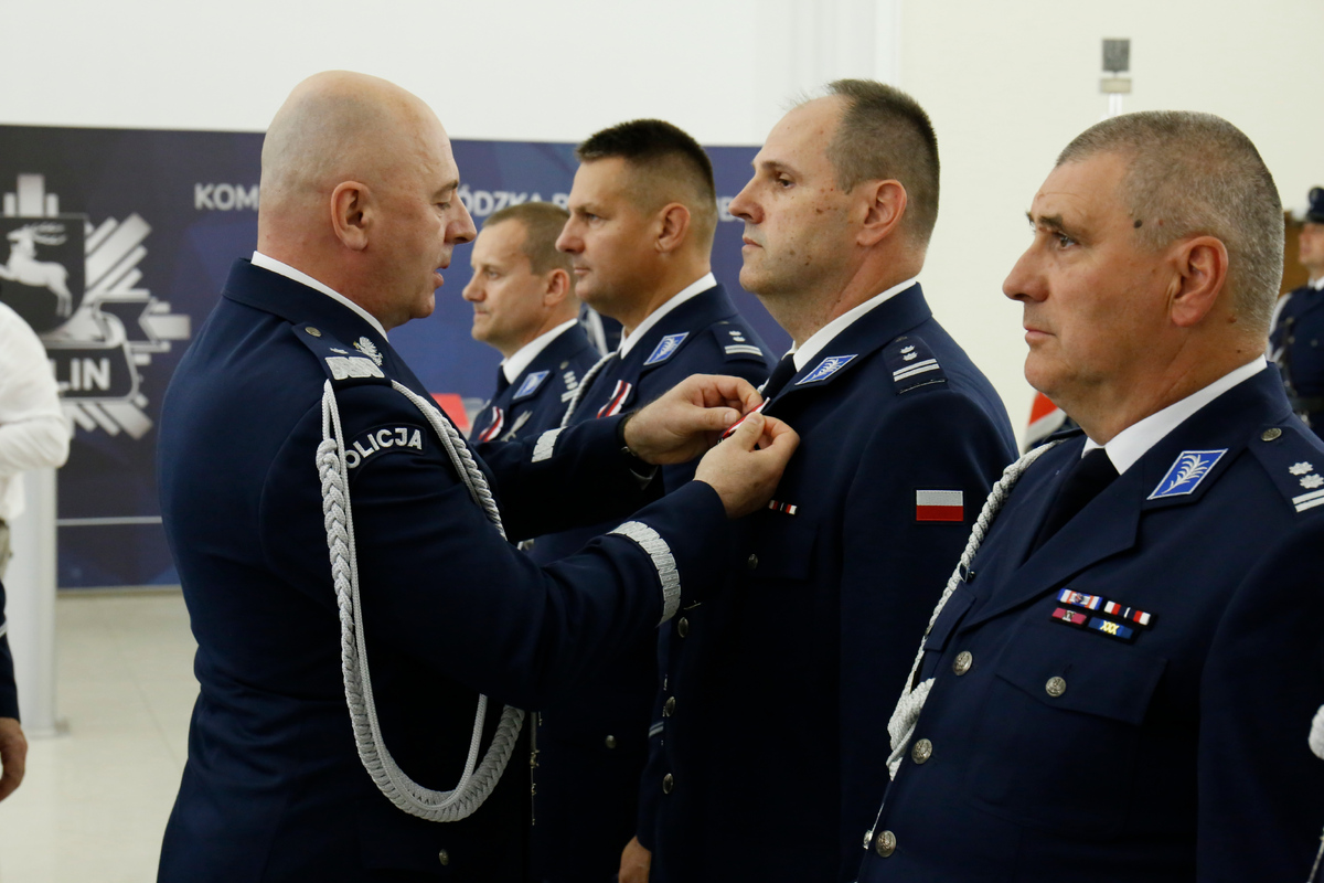 Zastępca Komendanta Głównego Policji nadinsp. dr Rafał Kochańczyk przypina medal policjantowi