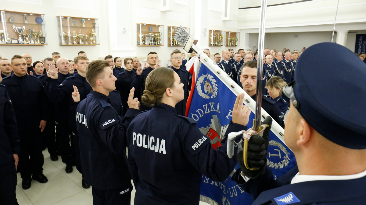 Młodzi funkcjonariusze wypowiedają słowa policyjnej roty ślubując na sztandar Komendy Wojewódzkiej Policji w Lublinie.