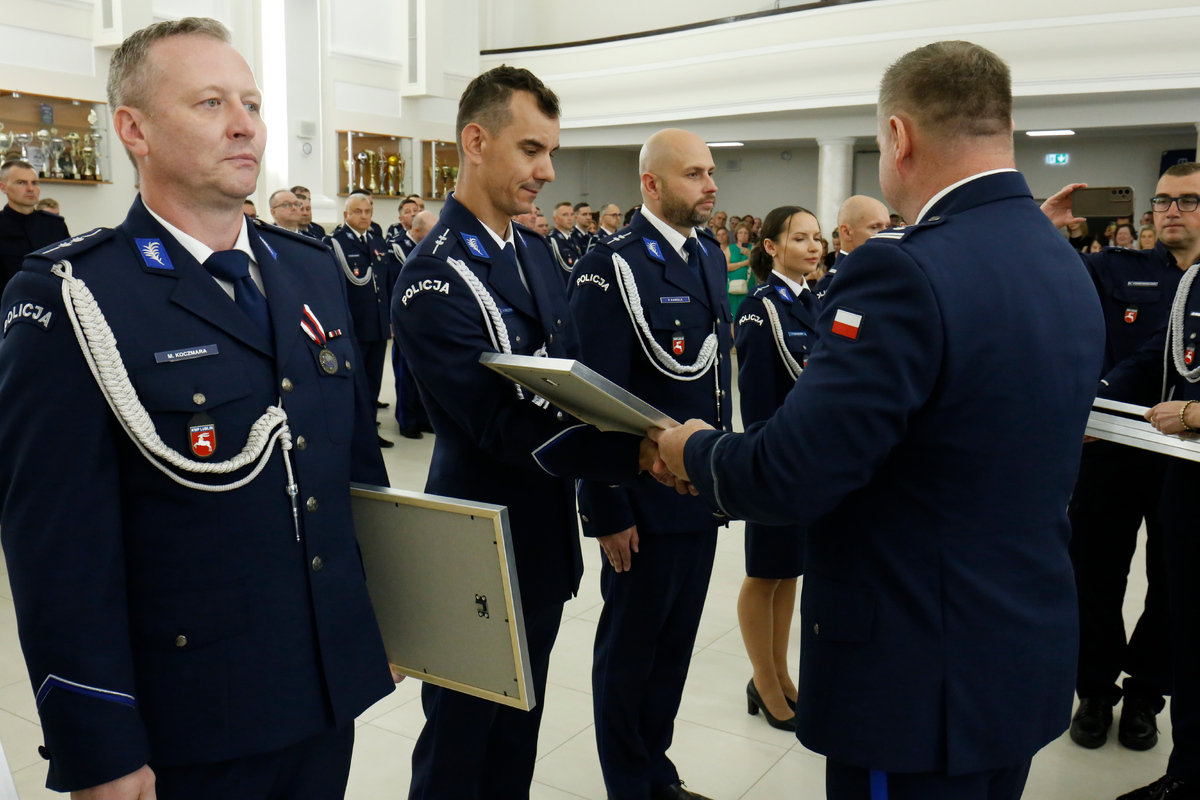 Komendant Wojewódzki Policji w Lublinie inspektor Tomasz Gil wręcza pamiątkowe ryngrafy policjantom. 