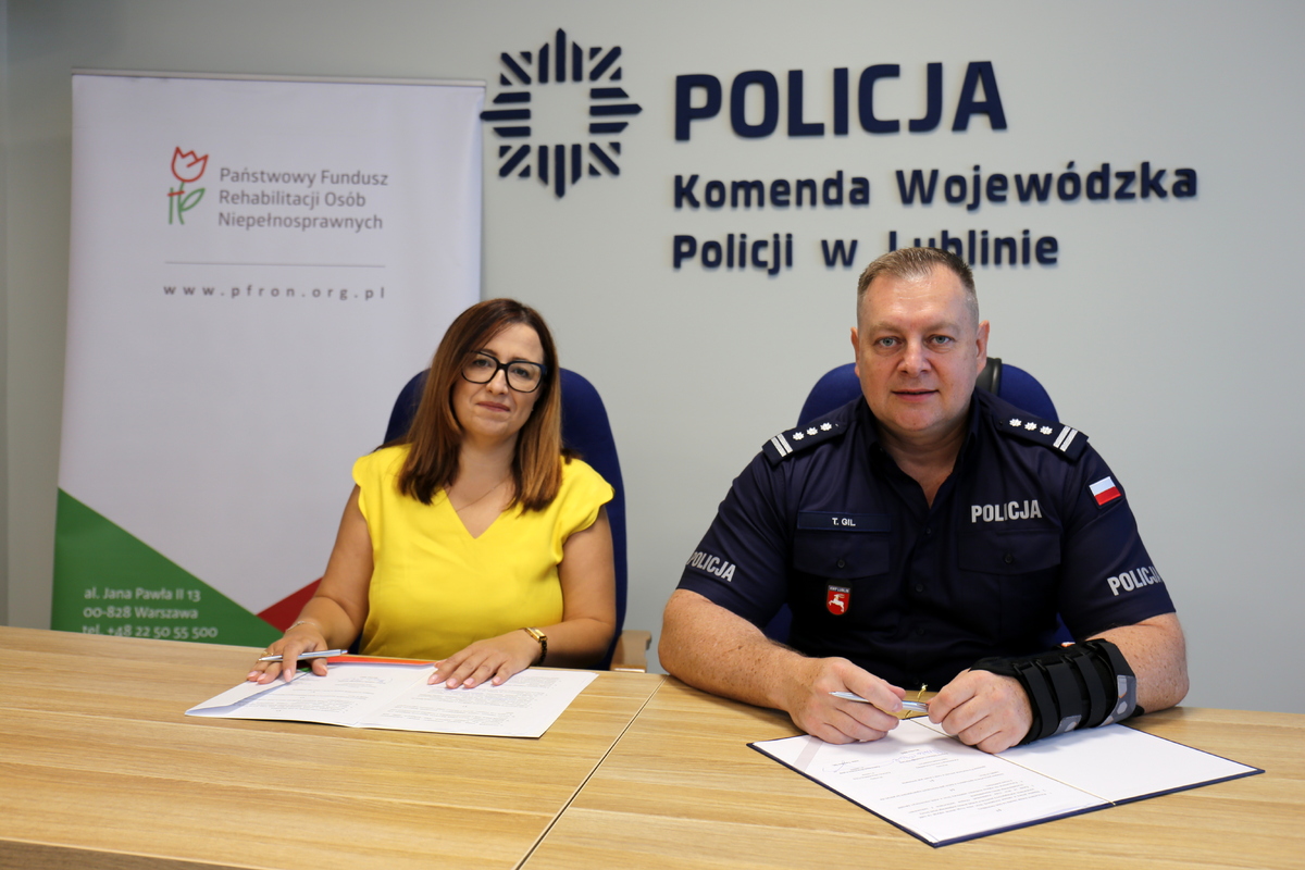 Komendant Wojewódzki Policji w Lublinie- inspektor Tomasz Gil oraz reprezentująca Państwowy Fundusz Rehabilitacji Osób Niepełnosprawnych Dyrektor Oddziału Lubelskiego PEFRON - Pani Monika Wac podczas podpisywania umowy