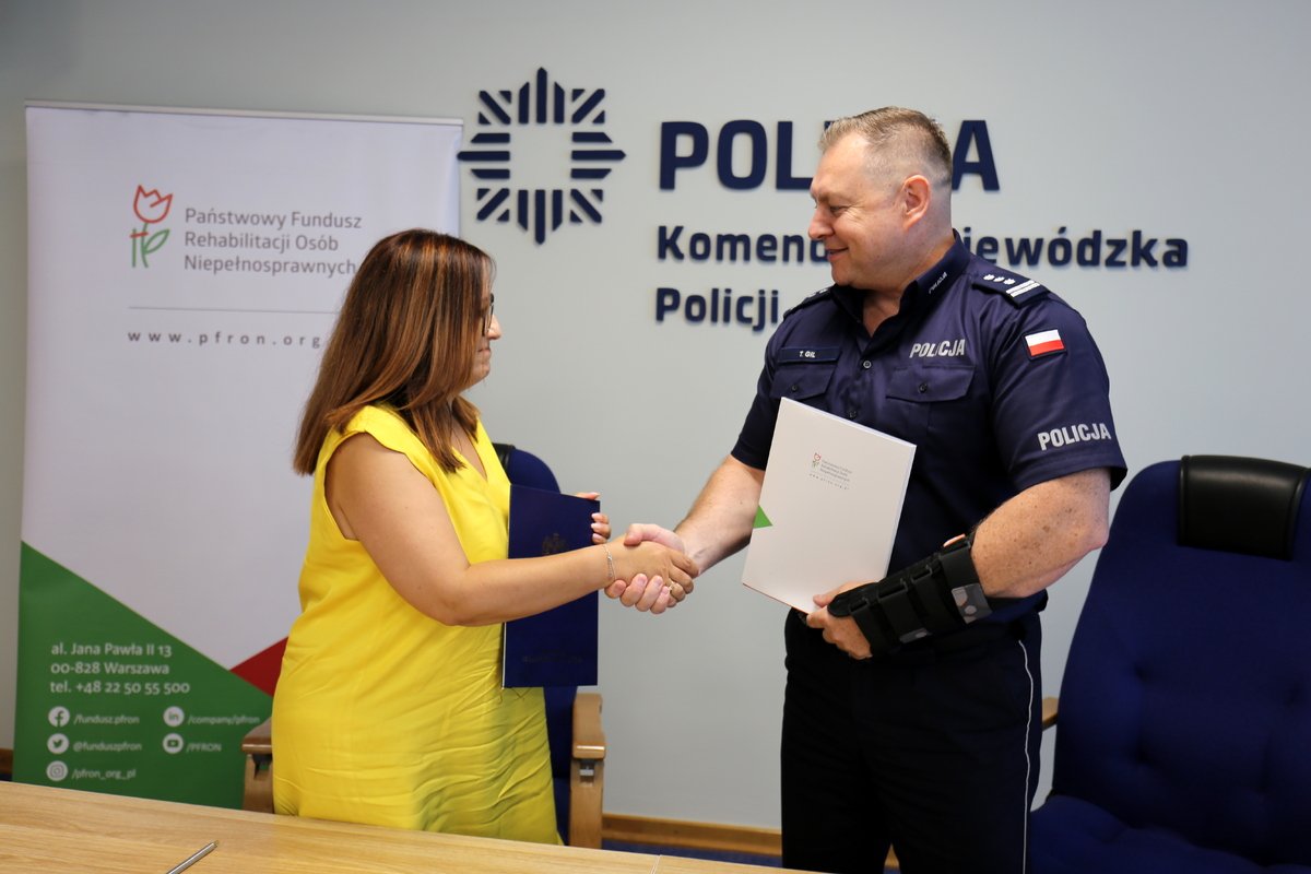Komendant Wojewódzki Policji w Lublinie- inspektor Tomasz Gil oraz reprezentująca Państwowy Fundusz Rehabilitacji Osób Niepełnosprawnych Dyrektor Oddziału Lubelskiego PEFRON - Pani Monika Wac podczas podpisywania umowy