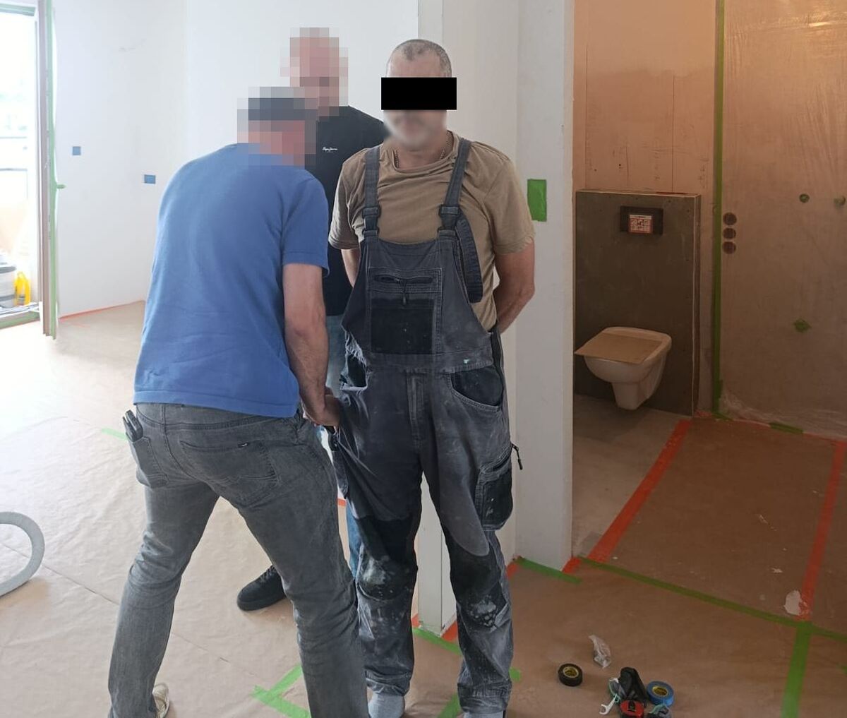 policjanci podczas zatrzymania poszukiwanego mężczyzny