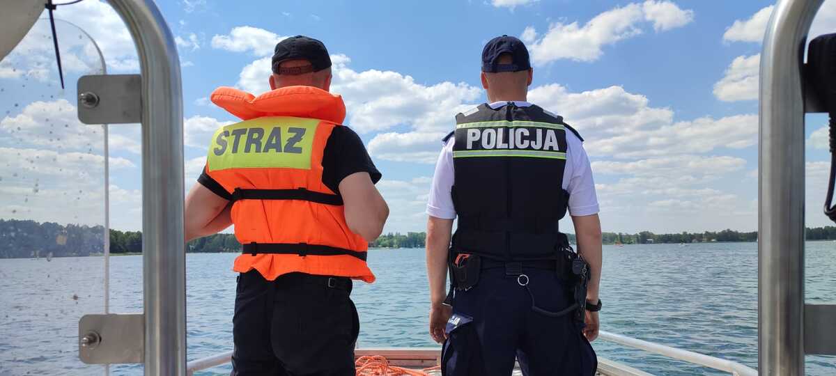 policjant ze strażakiem na łodzi na wodzie