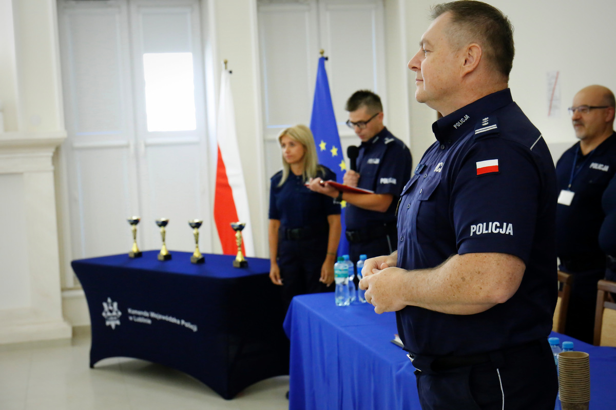 W pierwszym planie Komendant Wojewódzki Policji w Lublinie - inspektor Tomasz Gil. W drugim planie komisja sędziowska złożona z funkcjonariuszy KWP w Lublinie oraz puchary dla najlepszych policjantów konkursu.