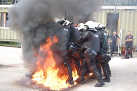 Symulacja zamieszek ulicznych - funkcjonariusze pokonują przeszkodę w ogniu