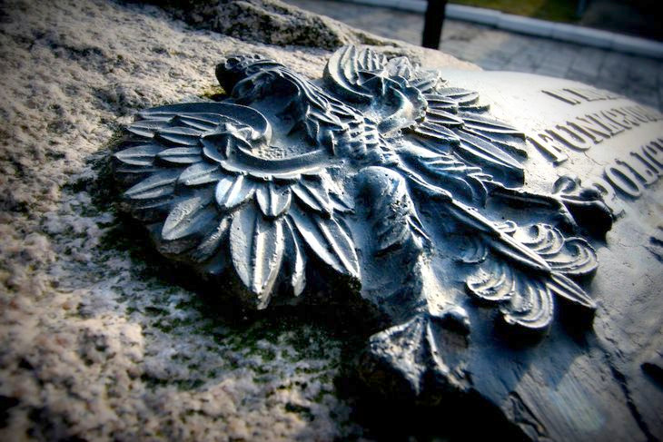 Pomnik-tablica poświęcony jest pomordowanym policjantom II Rzeczpospolitej. Na zdjęciu widnieje godło Państwa Polskiego