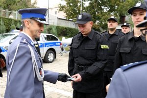 Komendant Wojewódzki Policji w Lublinie gratuluję nowemu funkcjonariuszowi i wręcza mu legitymacje służbową.