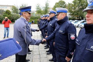 Komendant Wojewódzki Policji w Lublinie wręcza kluczyki do nowego radiowozu policjantowi.
