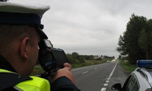 policjant mierzący prędkość miernikiem prędkości