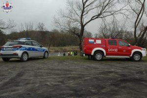 radiowóz, policjanci i strażacy w trakcie poszukiwań zaginionego