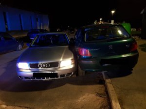 dwa uczestniczące w kolizji pojazdy, audi i peugeot