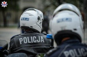 dwaj policjanci w kaskach z napisem policja
