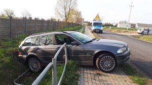 osobowe BMW staranowało barierki. Na drugim planie policyjny radiowóz.