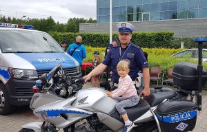 dziecko na policyjnym motocyklu pozuje do zdjęcia