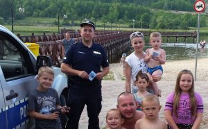 policjant z osobami wypoczywającymi nad zalewem w Krasnobrodzie