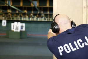 Policjant strzela do tarczy.