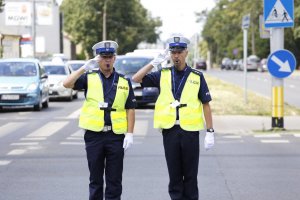 Policjanci ruchu drogowego oddają honor.
