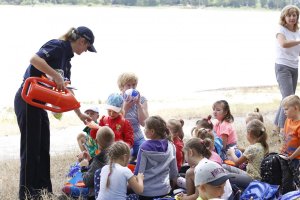 Policjantka daje dzieciom upominki.