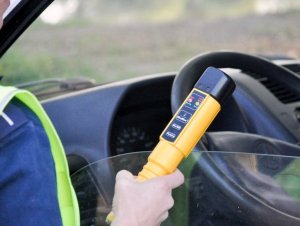 policjant trzyma w ręku alcoblow