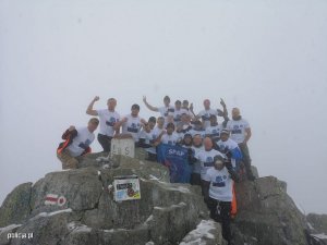 zdjęcie grupowe na szczycie. Dookoła śnieg, pozujący w podkoszulkach