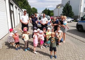 policjanci z dziećmi idą po chodniku