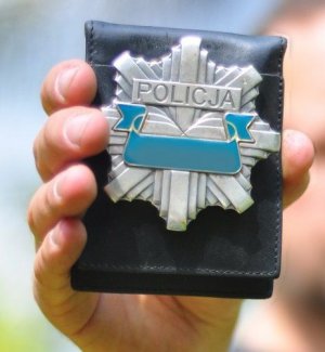 policyjna odznaka trzymana w ręku