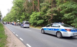 radiowóz oraz policjanci zabezpieczający przejście pielgrzymki