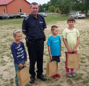 fot. nagrodzone dzieci z policjantem w tle